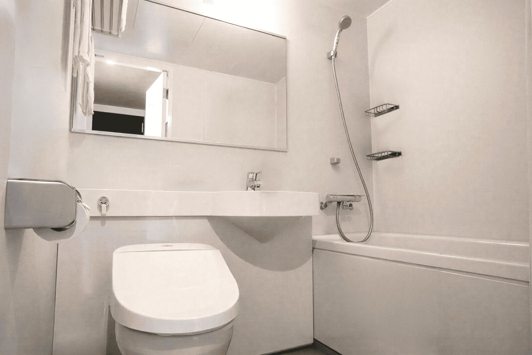 A bathroom with a toilet, sink, and shower.