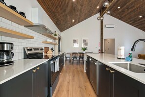 Eine moderne Küche mit Kochinsel, eingebauten Geräten und Holzboden.