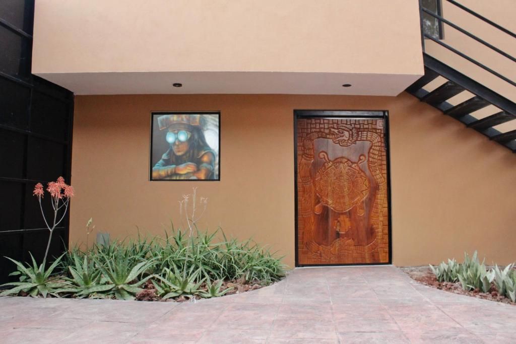 A modern building entrance with a staircase, a framed artwork, and a decorative door.