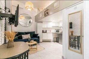 Ein modernes Wohnzimmer mit Sofa, Couchtisch und Essbereich mit Tisch und Stühlen.