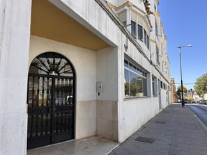 A building with a large arched entrance, a visible electrical box, and a clear sky. - Apartamento Texas Life - Ole Solutions (Jerez de la Frontera)