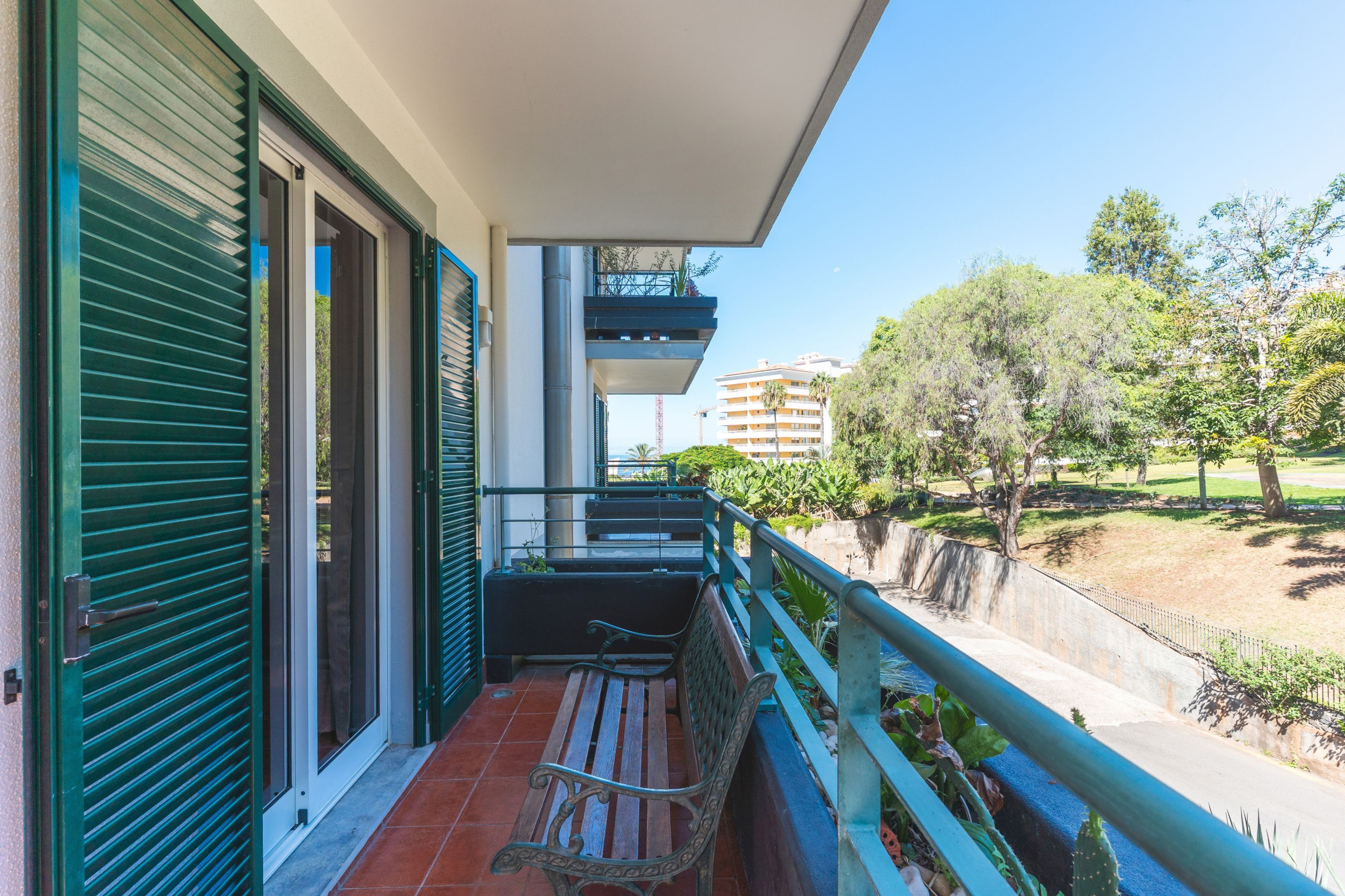 A balcony with a view of a park and buildings.