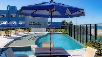 Piscina a l'aire lliure, para-sols i gandules