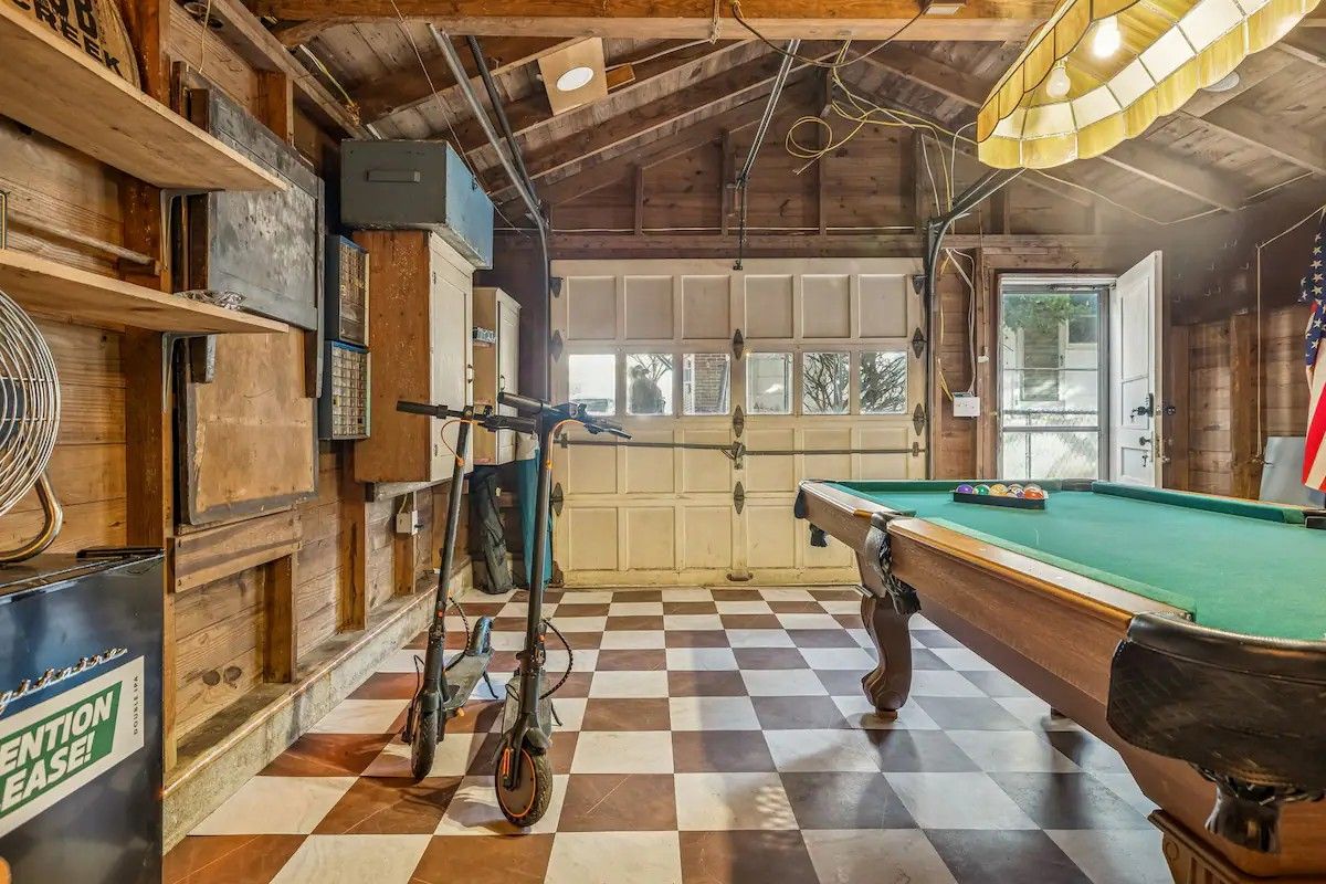A room with a pool table, a bicycle, and a dartboard.