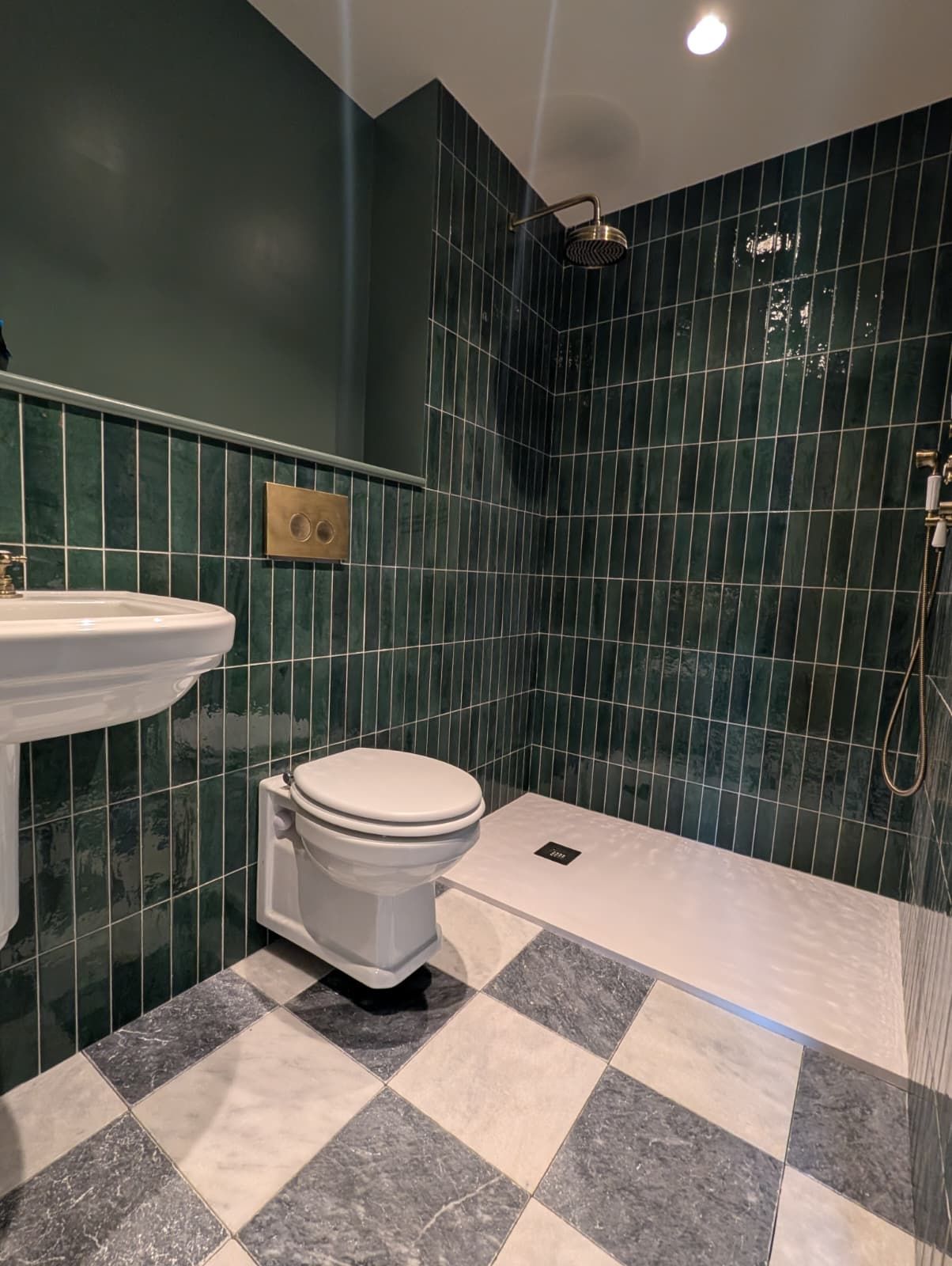 A bathroom with a white toilet, a sink, and a shower area.