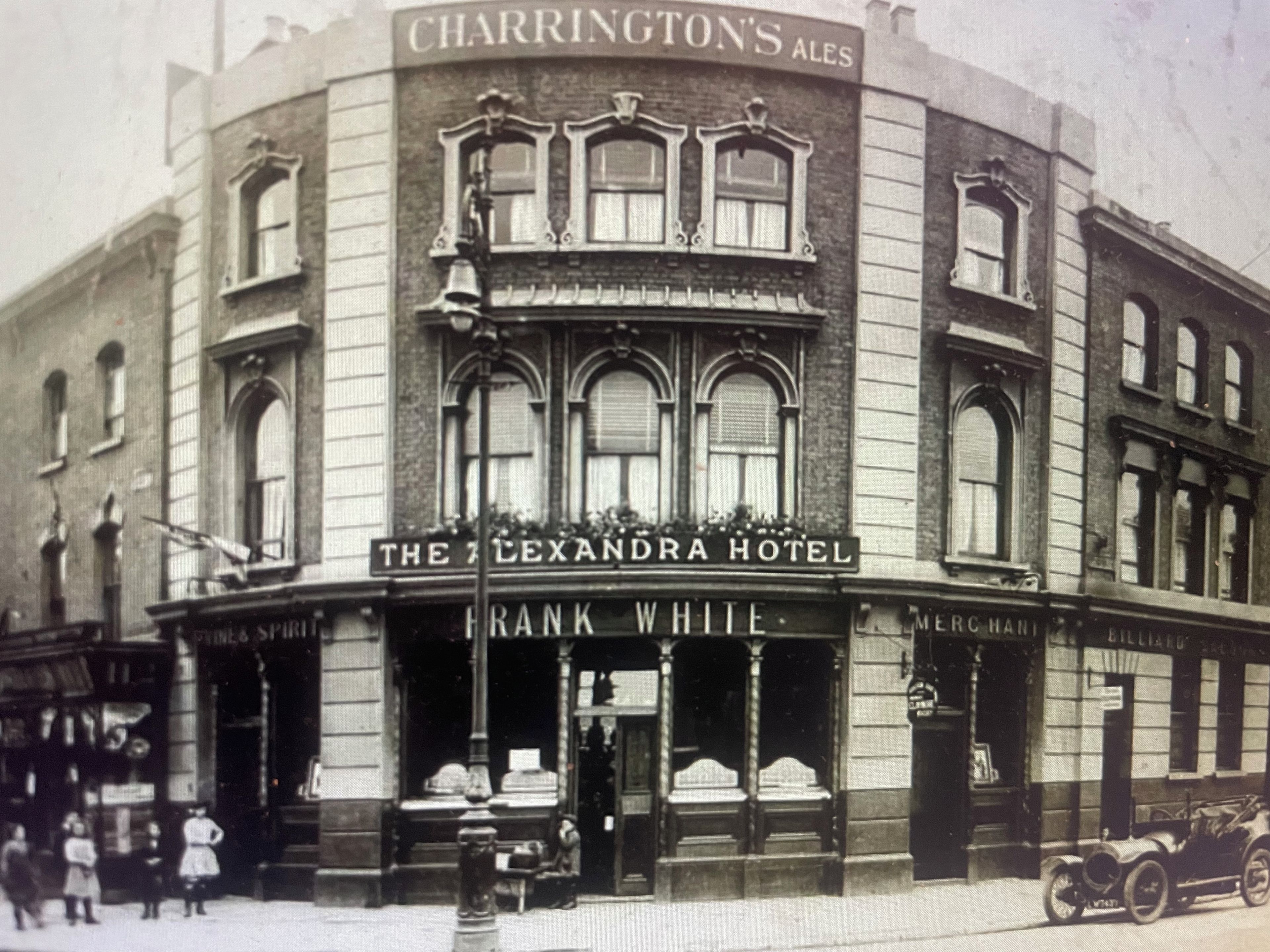 A historic building with a sign for 'The Alexandra Hotel' and 'Frank White' on the ground floor.