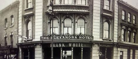 A historic building with a sign for 'The Alexandra Hotel' and 'Frank White' on the ground floor.