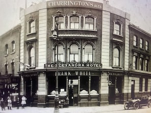 A historic building with a sign for 'The Alexandra Hotel' and 'Frank White' on the ground floor. - The Lauriston Pub & Guest Rooms (London)