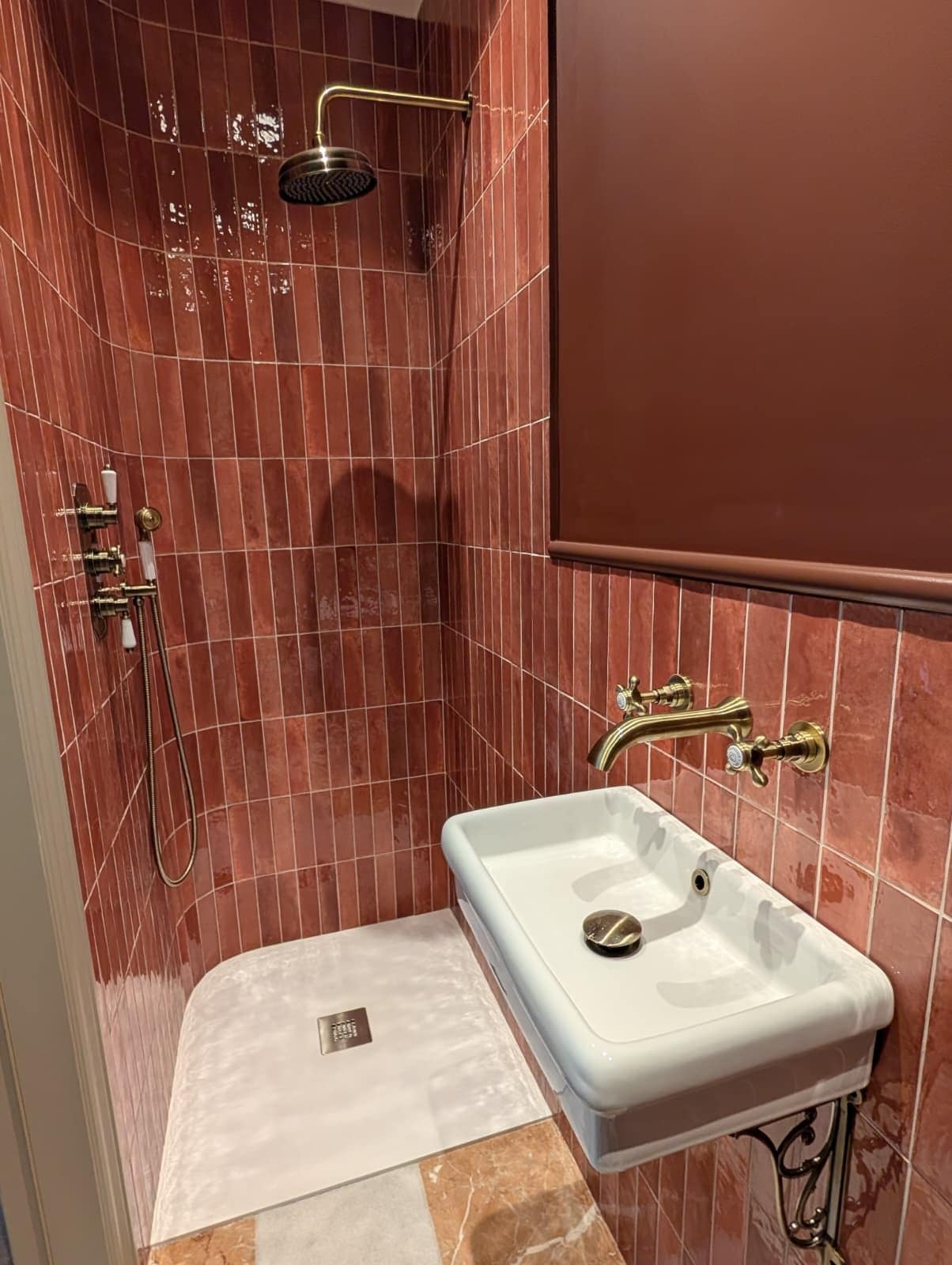 A bathroom with a shower, a sink, and a mirror.