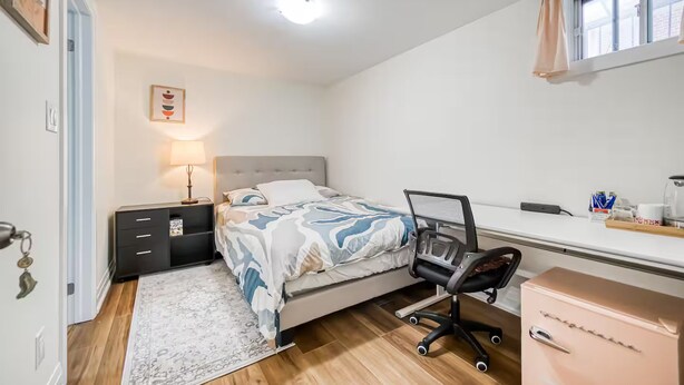 Quarto com cama, mesa de cabeceira, abajur, escrivaninha, cadeira e cômoda.