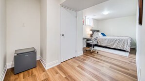 Quarto com cama, escrivaninha e cadeira.