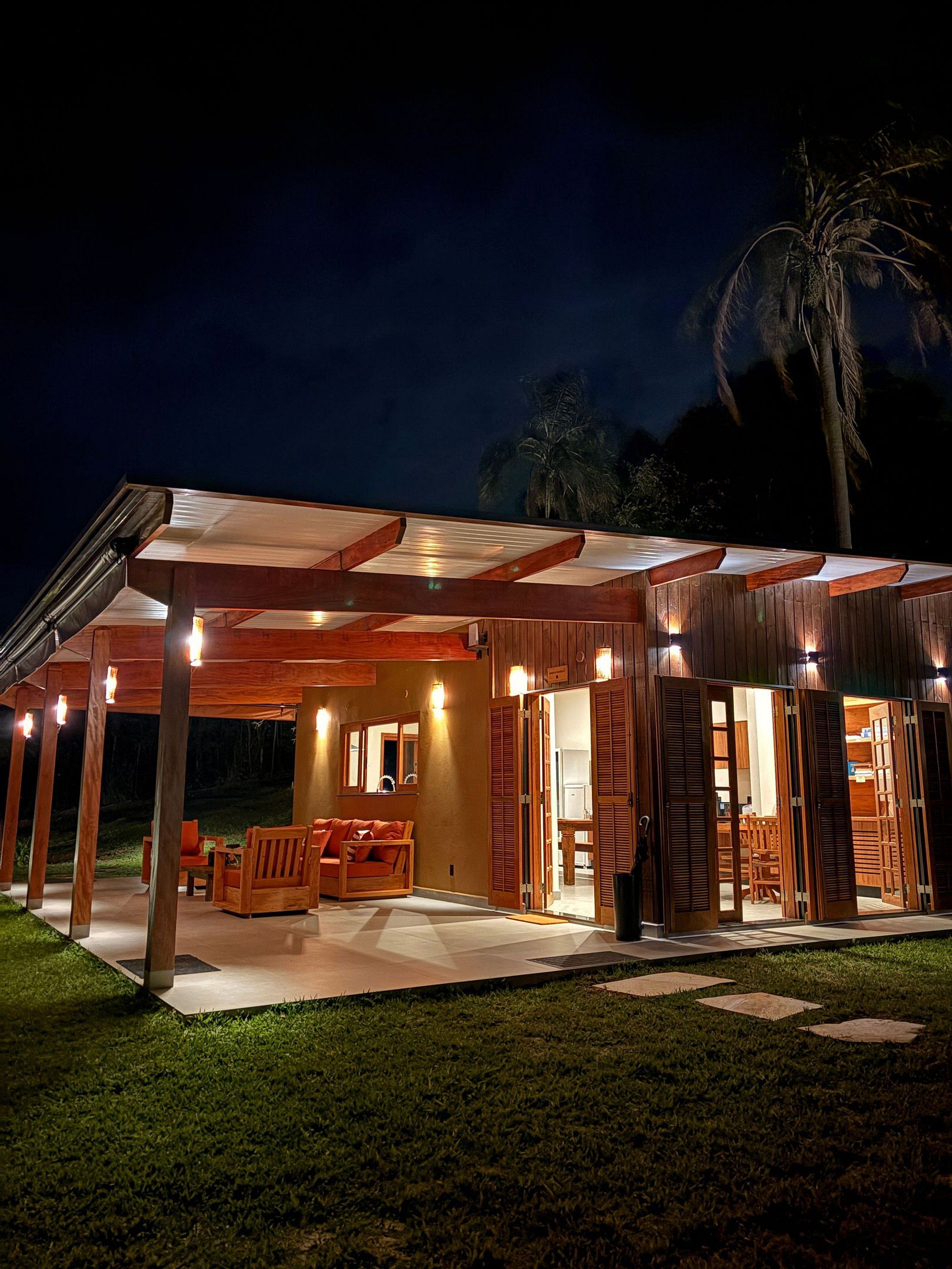 Un espacio al aire libre techado con mobiliario de madera y una terraza.