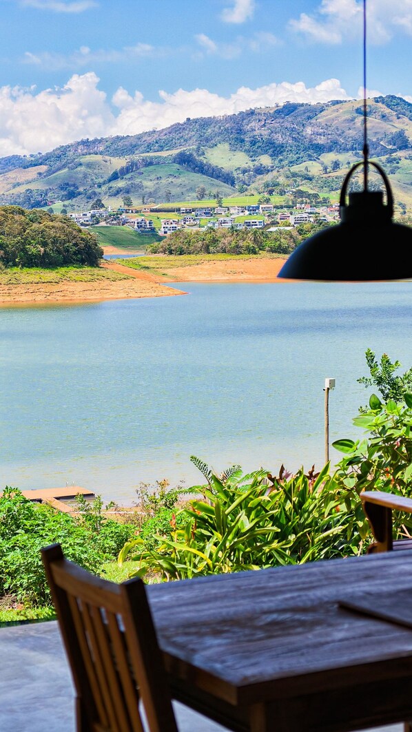 Un comedor con vistas a un lago y colinas.