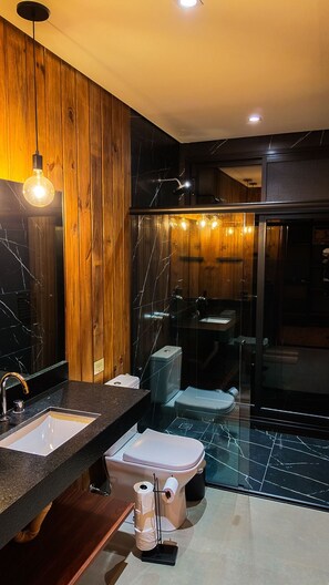 Ein modernes Badezimmer mit einem Holzbadezimmermöbel, einer Duschkabine aus Glas und einem Marmorboden.