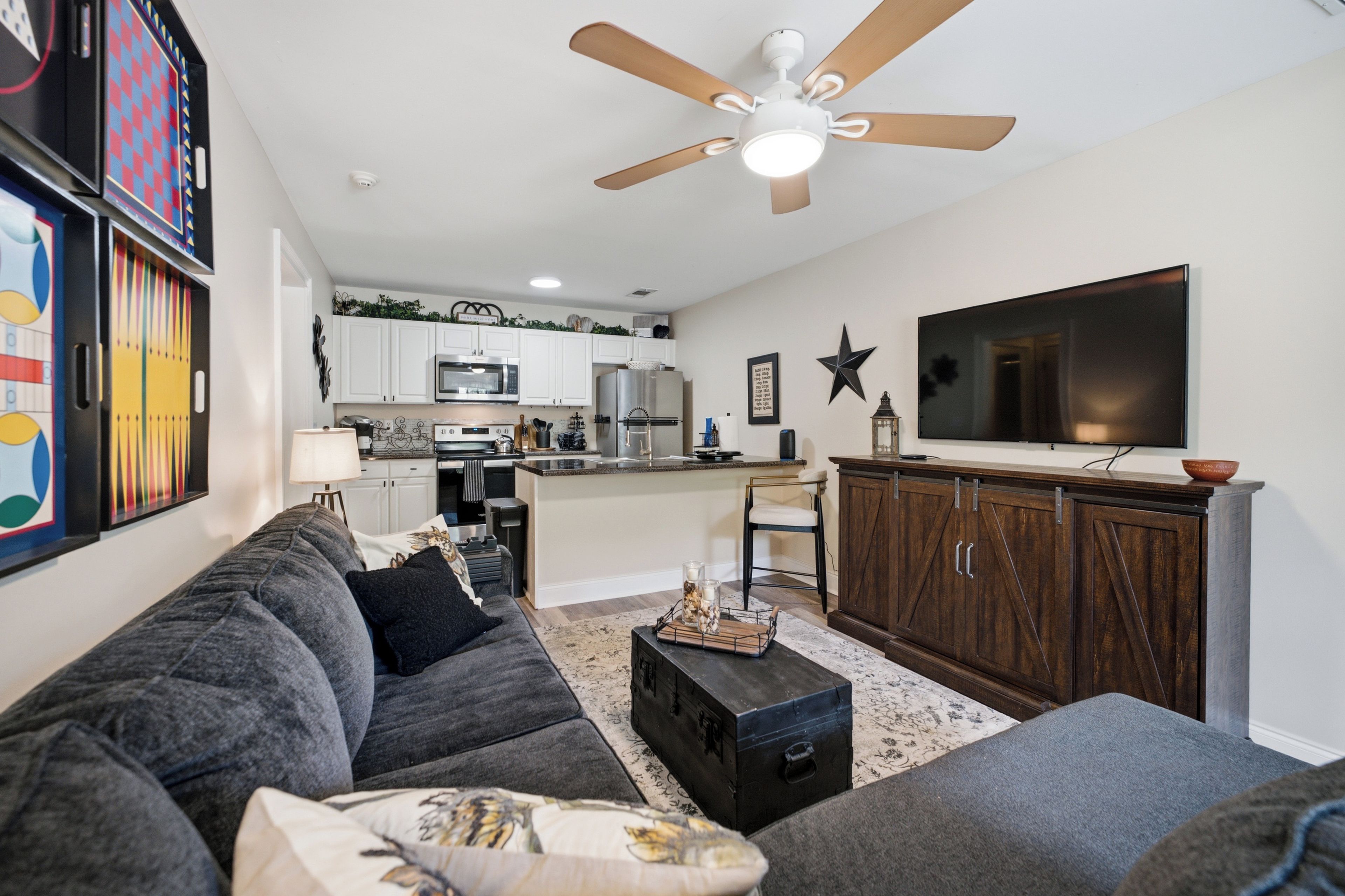 A modern living room with a grey sofa, a coffee table, and a TV on a wooden cabinet.