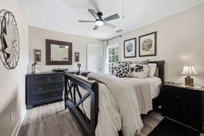 Une chambre à coucher avec un lit, une commode et un ventilateur de plafond.