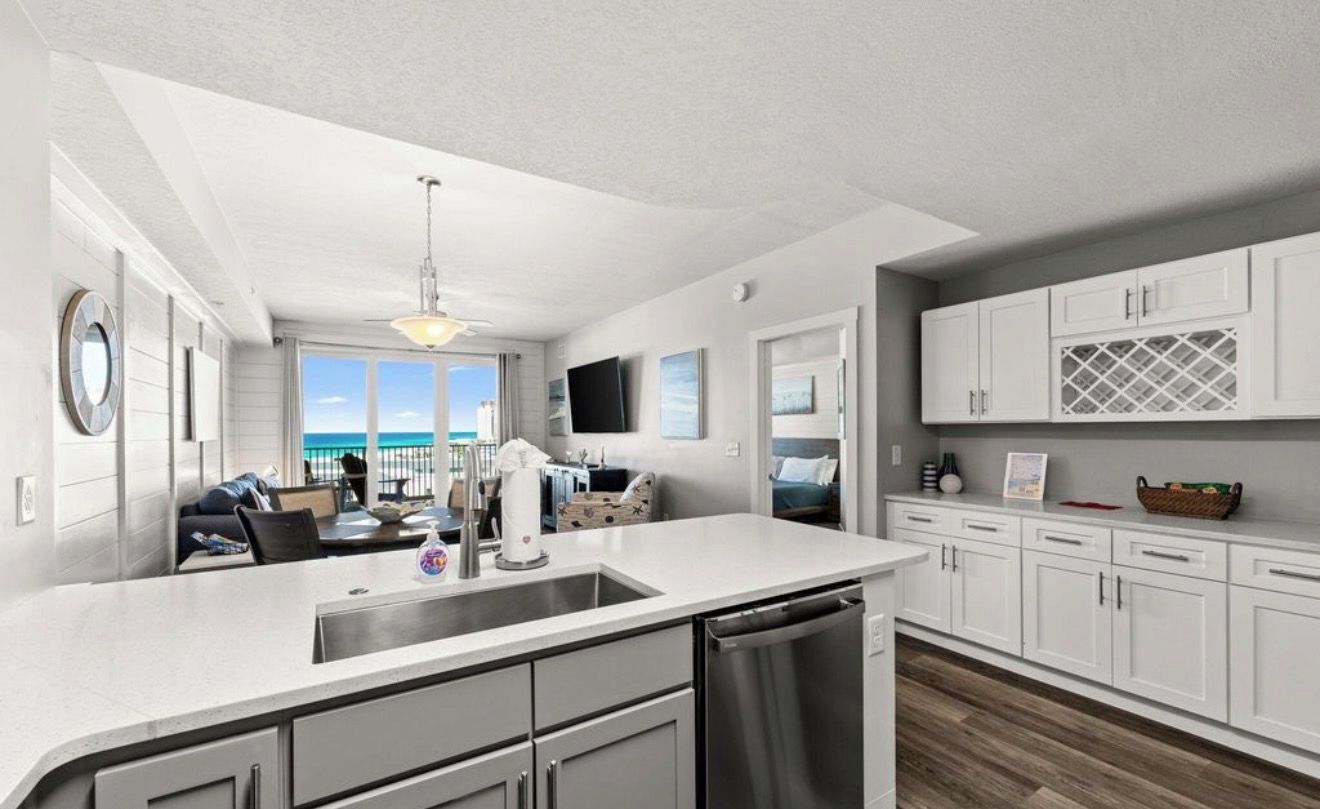 A modern kitchen with a large island, built-in appliances, and a view to the outside.