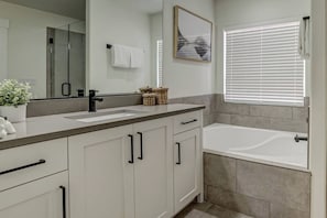 A modern bathroom with a double sink, a bathtub, and a large mirror. - Private Hot Tub, Fire Pit, BBQ, Heated Pool Near Zion & Sand Hollow (Washington)