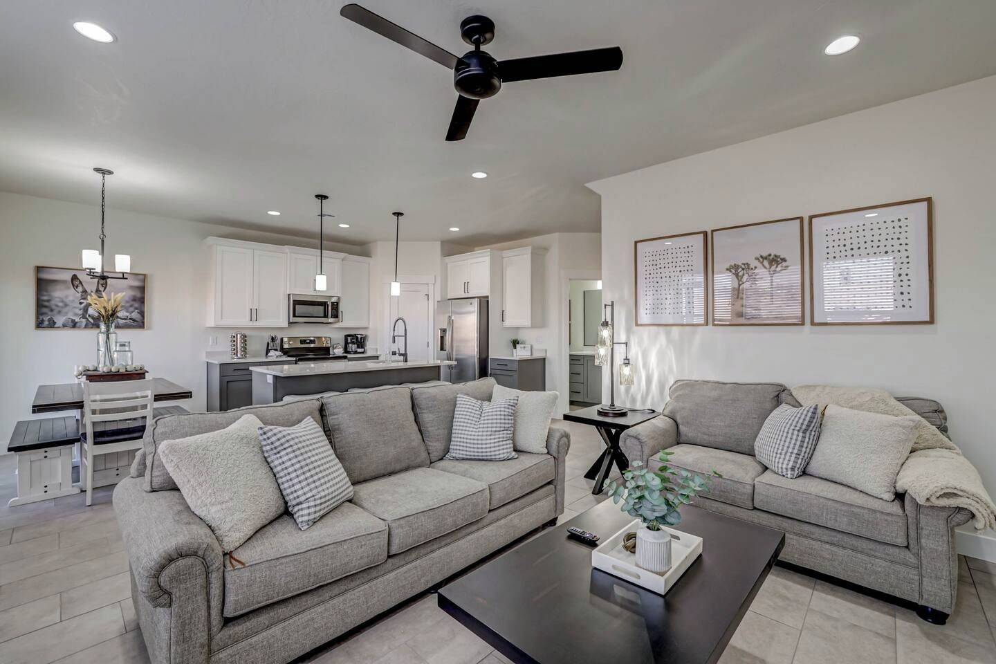 A modern living room with two sofas, a coffee table, and a dining area with a table and chairs.