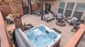 Ein Whirlpool in einer Außenbereich-Terrasse mit Sitzgelegenheiten und einem Feuerkorb.