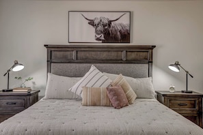 A bedroom with a bed, two bedside tables, a headboard, and a framed picture on the wall. - Private Hot Tub, Fire Pit, BBQ, Heated Pool Near Zion & Sand Hollow (Washington)