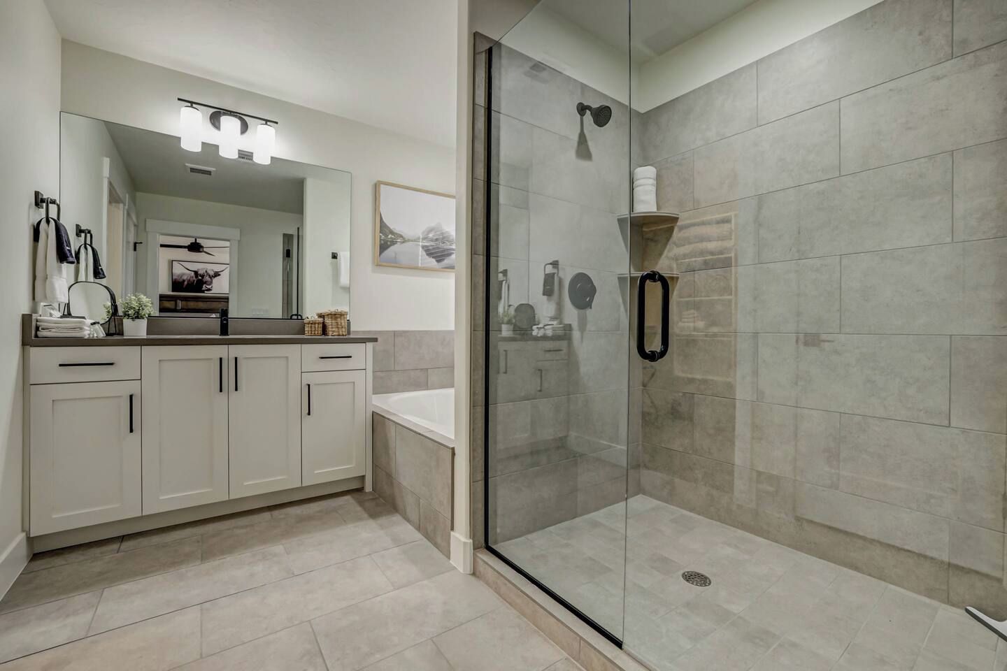 A modern bathroom with a glass-enclosed shower, a vanity with a mirror, and a sink.