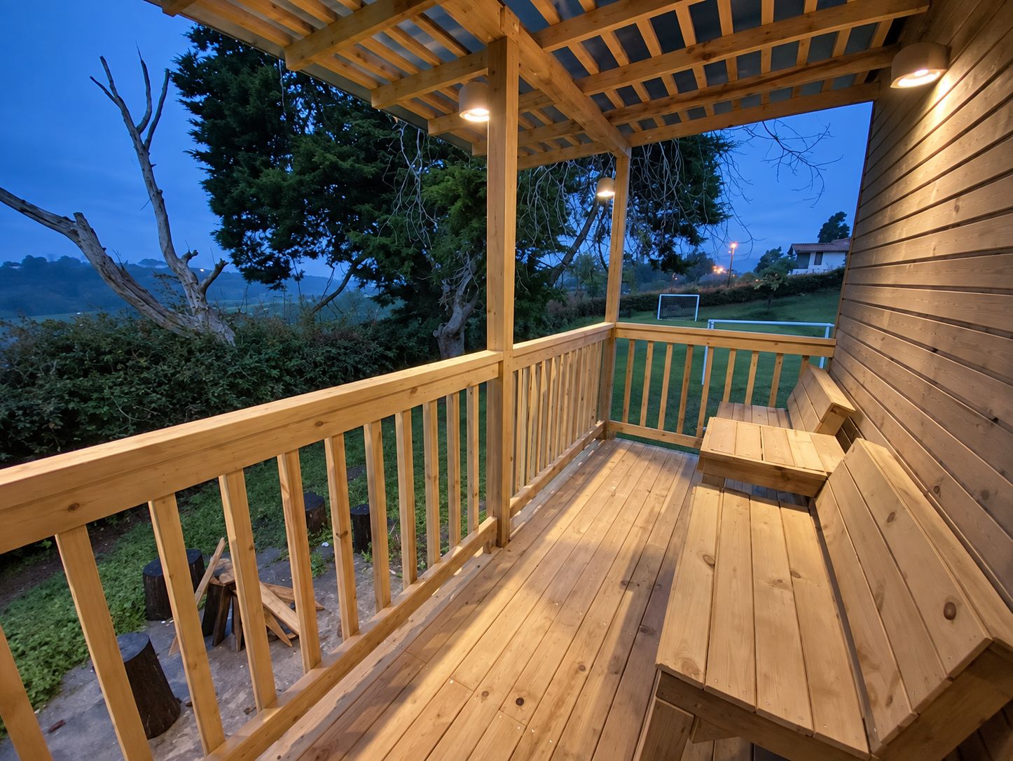 A wooden deck with a pergola, a table, and chairs.