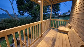 A wooden deck with a pergola, a table, and chairs.