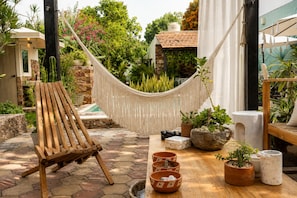 A hammock chair, a pool, and various potted plants in a garden setting. - 5-bedroom bed & breakfast in welcoming Mérida with AC (Mérida)