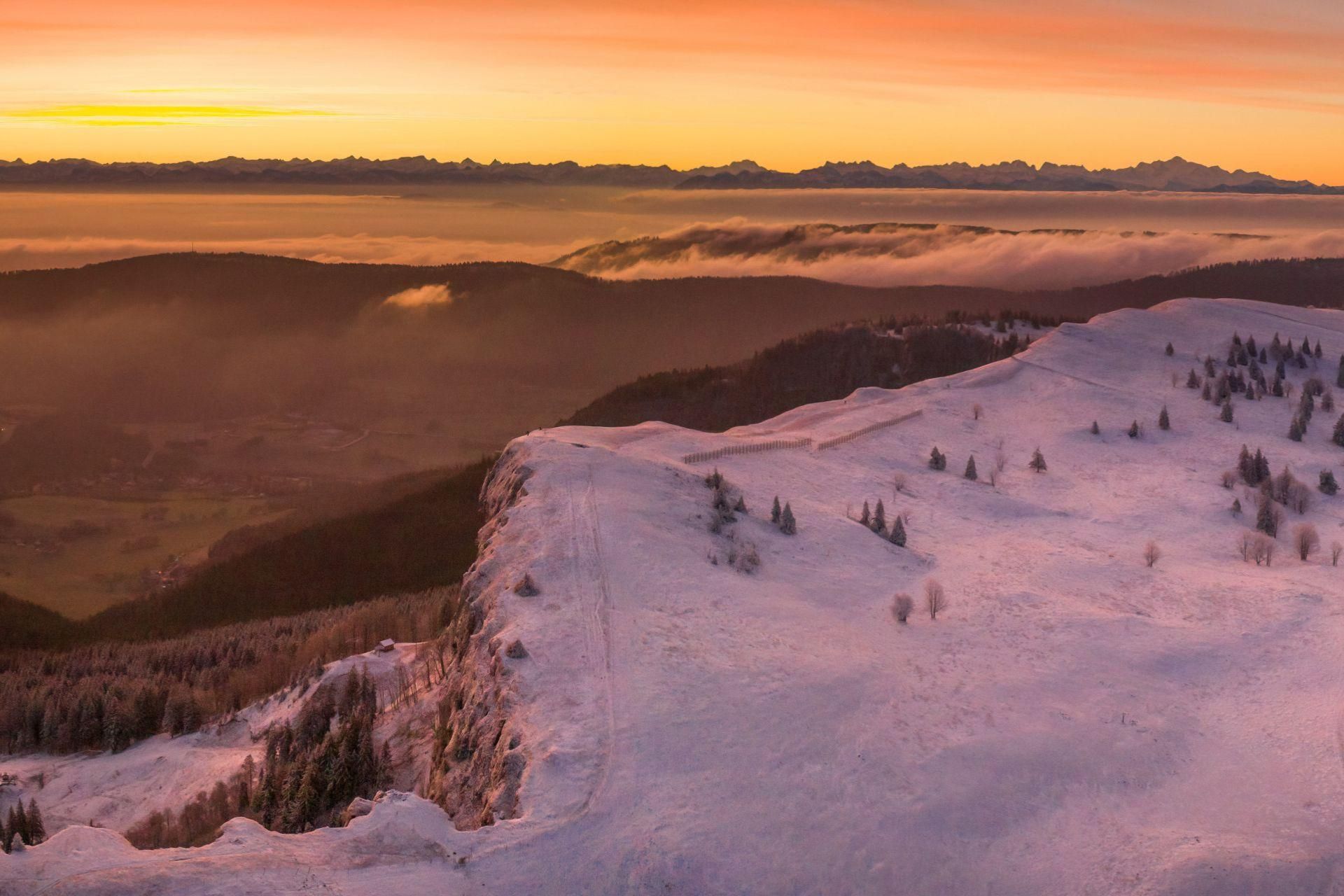 Een besneeuwd berglandschap met een heldere lucht en een verafgelegen bergketen.