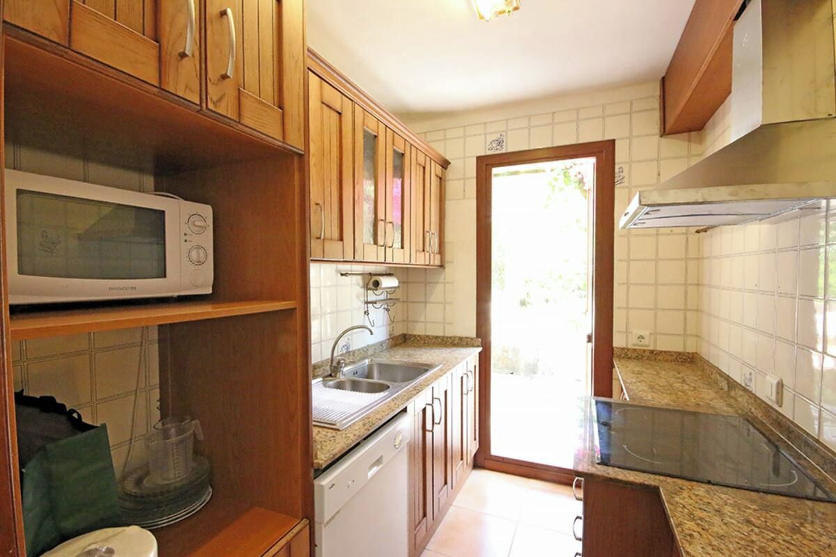 A kitchen with wooden cabinets, a microwave, a dishwasher, and a stove.