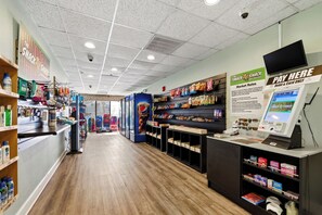 Eine Snackbar mit Regalen voller Snacks und Getränke, einer Pepsi-Werbung und einer Bezahldomäne.