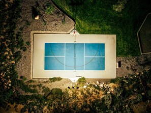 An aerial view of a rectangular swimming pool with a surrounding deck and a small garden area.