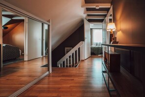A hallway with wooden flooring, a staircase, and a bed in the background. - Kaare’s Villa in Tromsø - Guest Favorite (Tromsø)