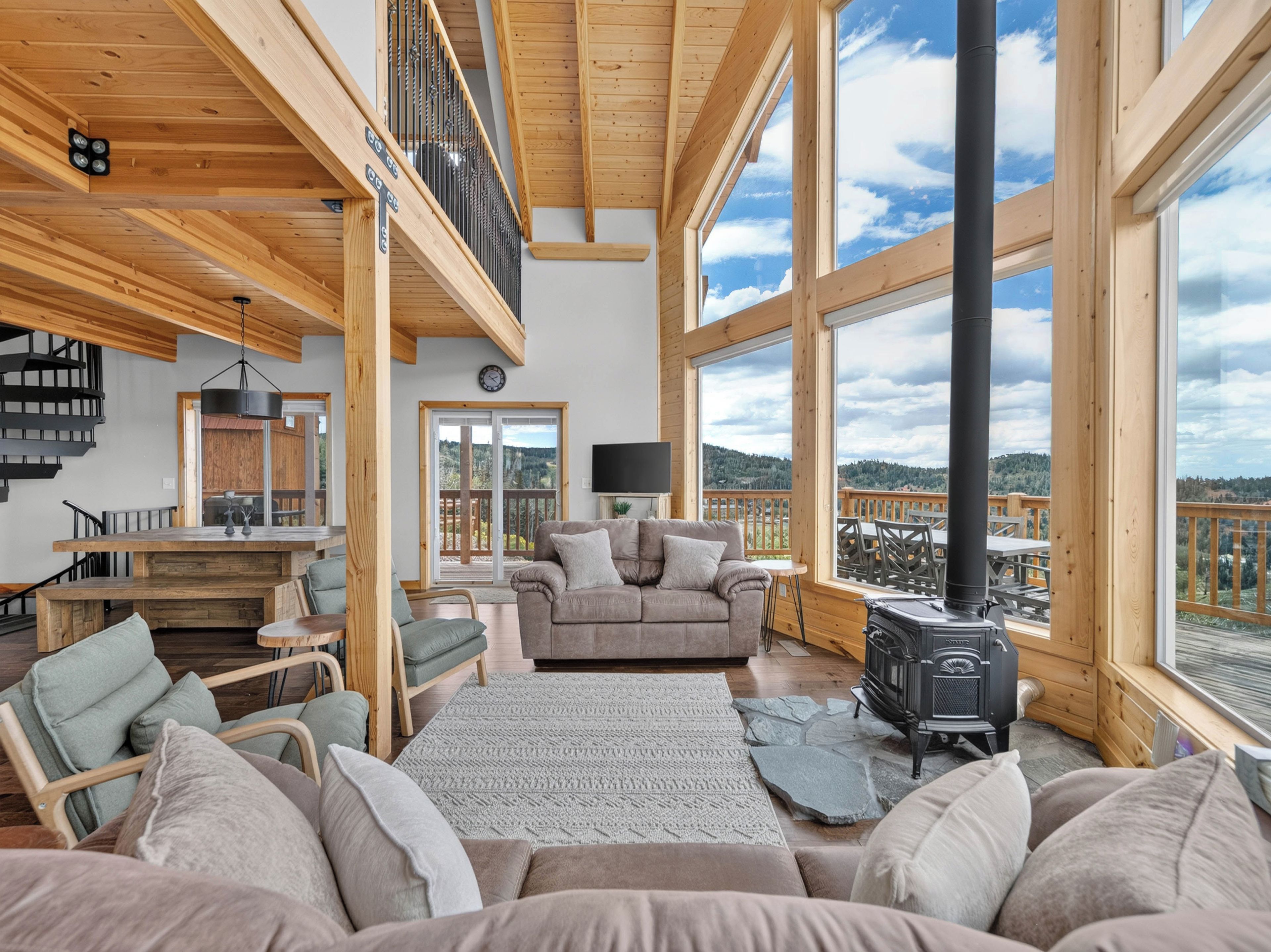 A spacious living area with a large window, a fireplace, and a cozy seating arrangement.