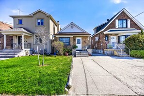 Una calle residencial con tres casas, cada una con un porche y escalones que llevan a la entrada.