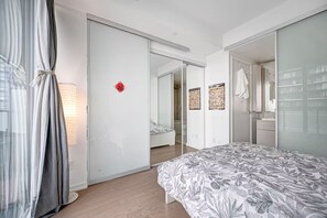 Una camera da letto moderna con un letto, un armadio e uno specchio.