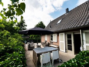 A patio area with a table and chairs, a grill, and a covered umbrella. - Holiday Home With 2 Bedrooms (Appelscha)