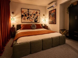 A bedroom with a large bed, two bedside tables, a wall-mounted air conditioner, and artwork. - Retro Park City Condo, 3BR + Loft, Near Major Ski Resorts (Park City)