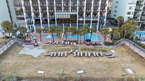 A hotel with multiple balconies, a swimming pool, and sun loungers. - Monterey Bay 1437 - Ocean Front (Myrtle Beach)