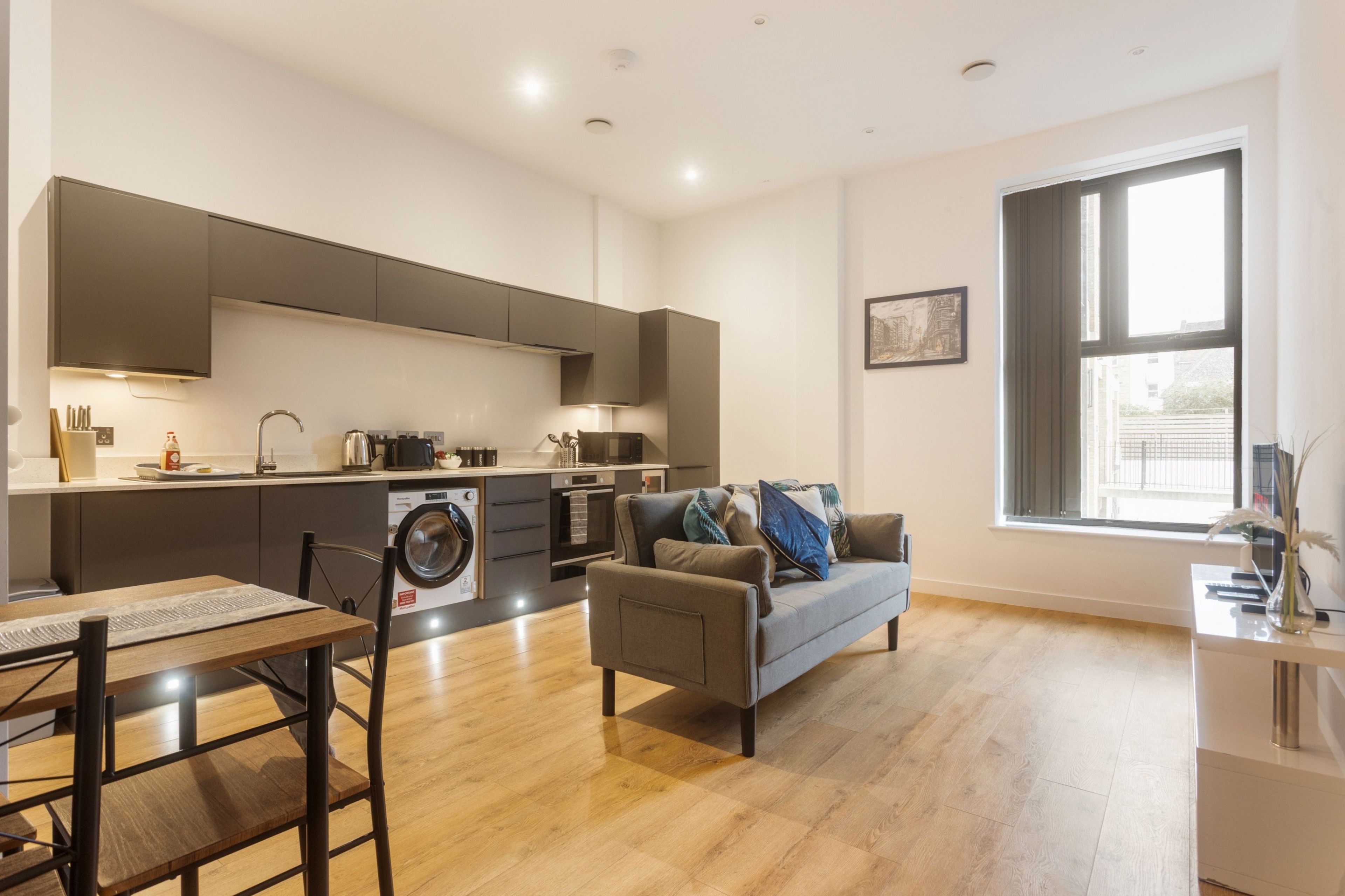 A modern apartment with a kitchen, dining area, and living room.