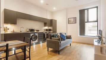 A modern apartment with a kitchen, dining area, and living room.