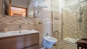 Un baño con ducha, bidé y lavamanos.