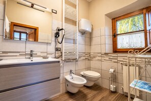 Un baño moderno con bidé, inodoro y lavamanos.