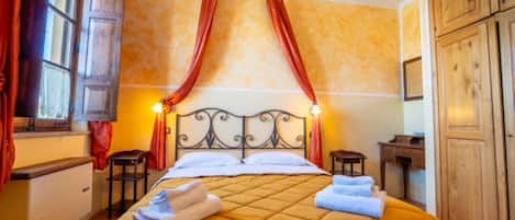 Una habitación de hotel con cama, cortinas, mesita de noche y armario.