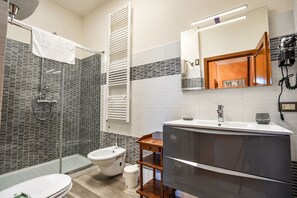 Un baño moderno con ducha, inodoro y lavamanos.