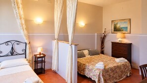 Un dormitorio con cama, mesita de noche, lámpara, cortinas y cómoda.