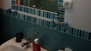 Ein Badezimmer mit Spiegel, Waschbecken und Handtuchhalter.