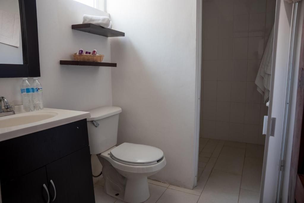 A bathroom with a toilet, a sink, and a shower area.