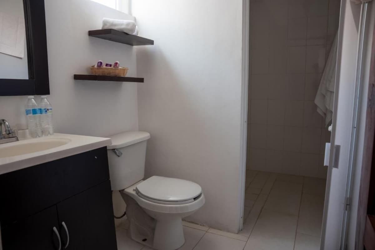 Een badkamer met toilet, wastafel en douche.